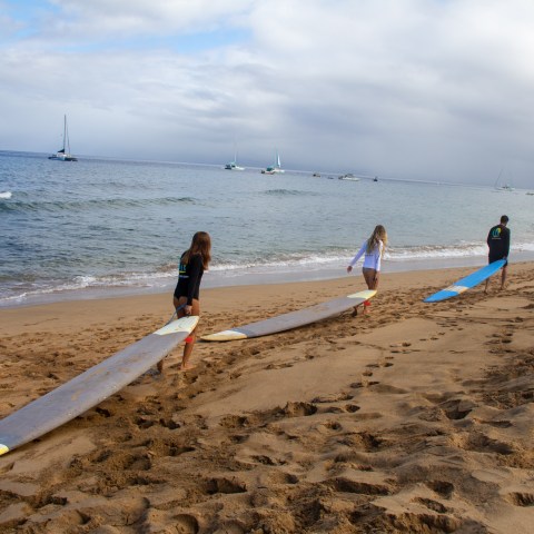a group of people standing on top of a sandy beach