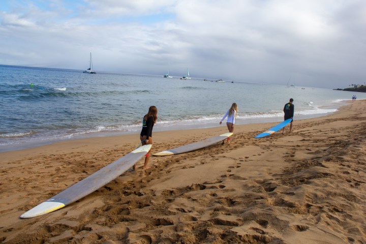 a group of people standing on top of a sandy beach