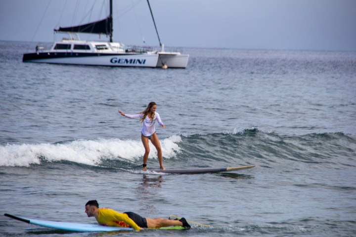 a man riding a wave on a surf board on a body of water