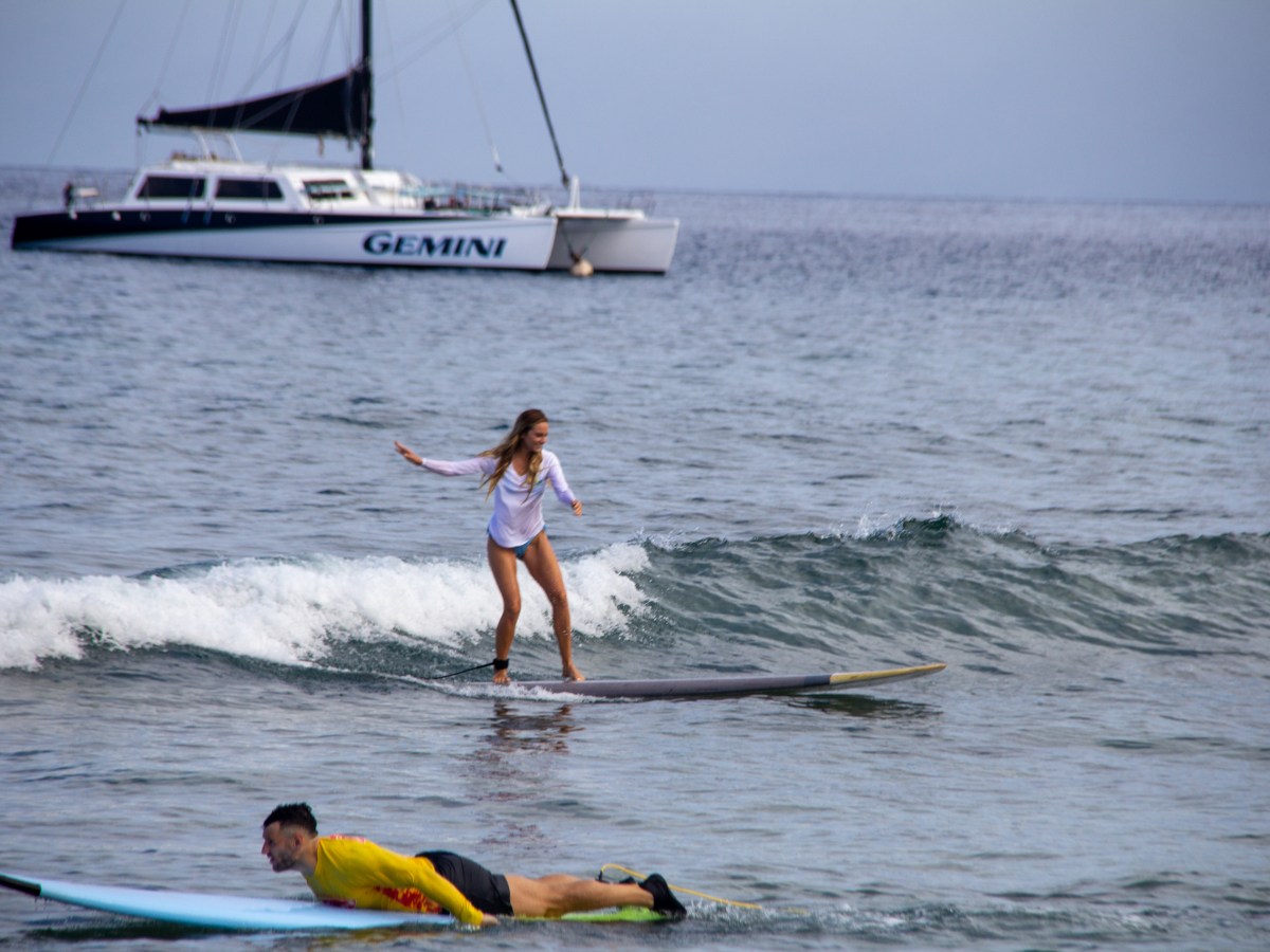 a man riding a wave on a surf board on a body of water
