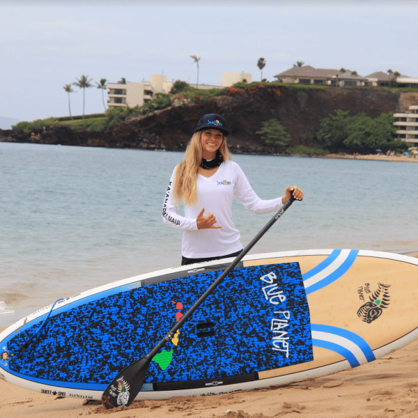 a person carrying a surf board on a body of water