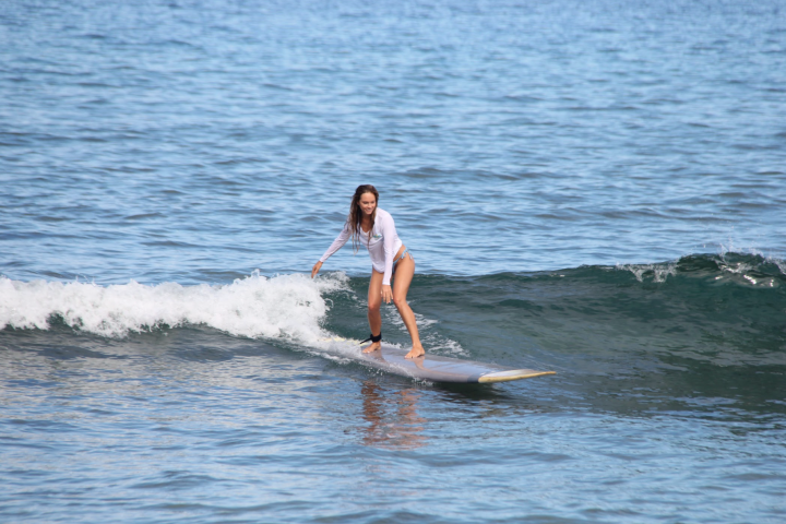 a girl riding a wave on a surfboard in the water