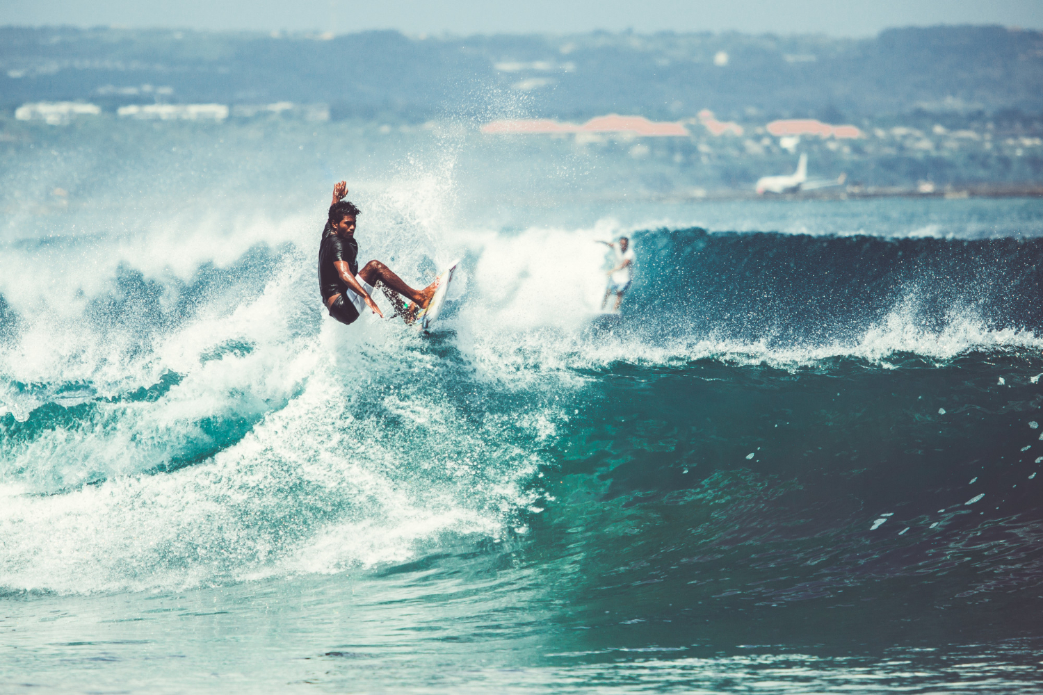 men-girls-are-surfing a man riding a wave on a surfboard in the ocean